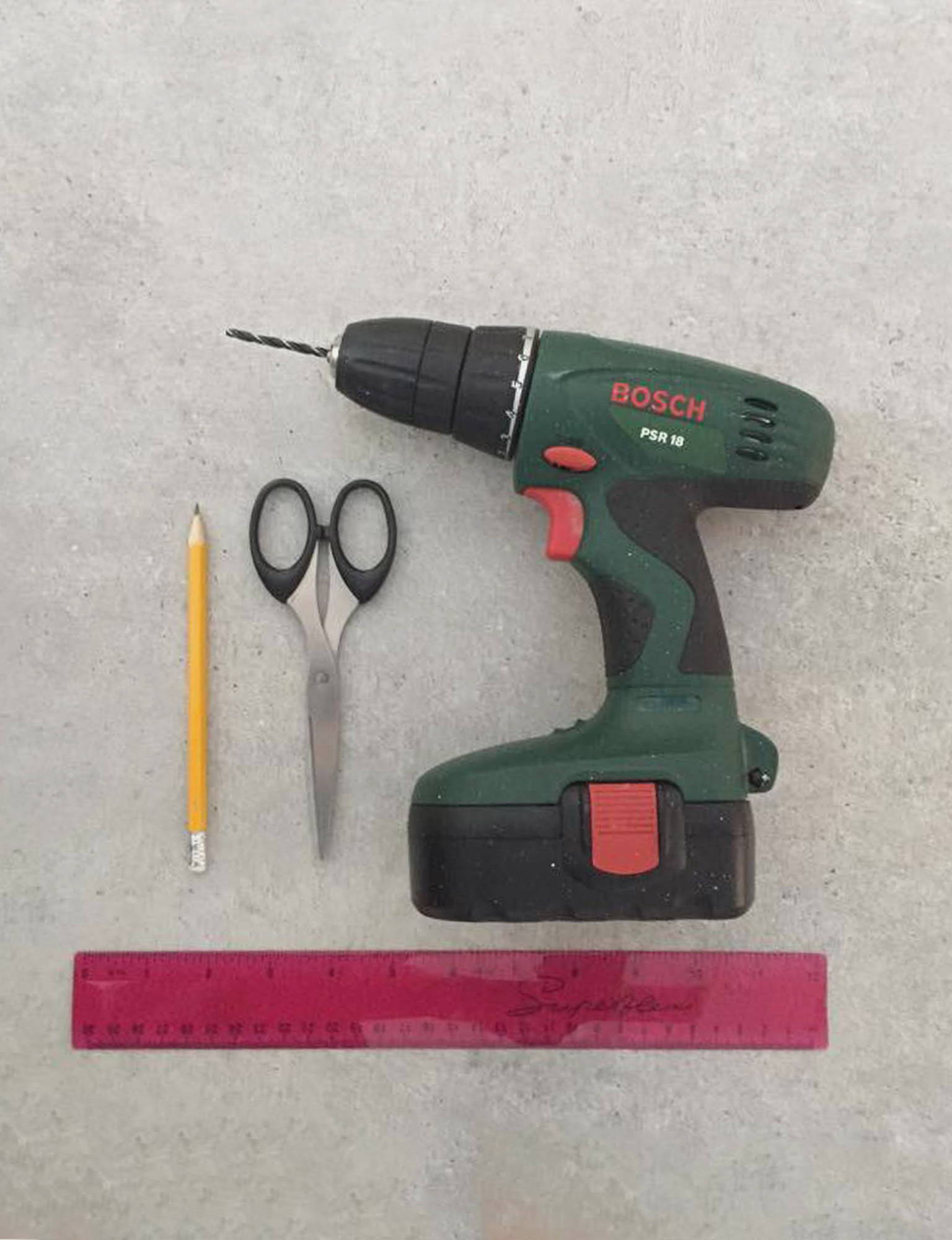 Image of a drill, ruler, pencil, scissors against a neutral background.
