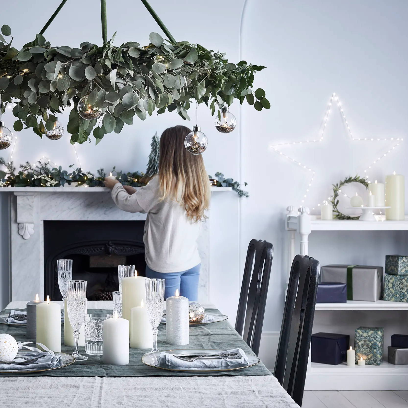 Christmas table setting with candles styled at centrepiece and giant Osby star displayed on mantel with Christmas garland 