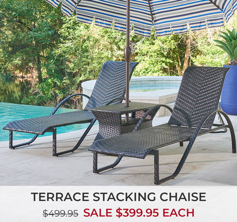 Two terrace stacking chaise lounges by a pool under an umbrella.