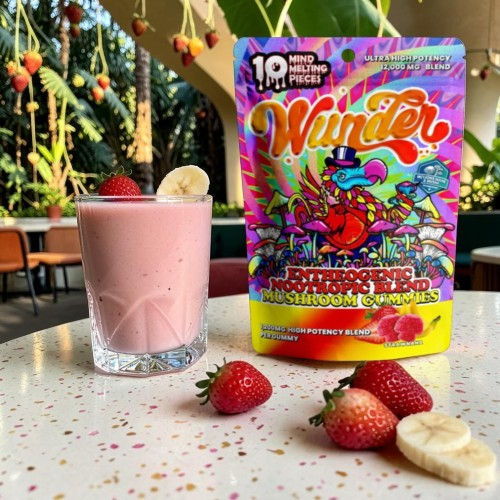 Smoothie with strawberries and banana next to colorful drink mix packet.