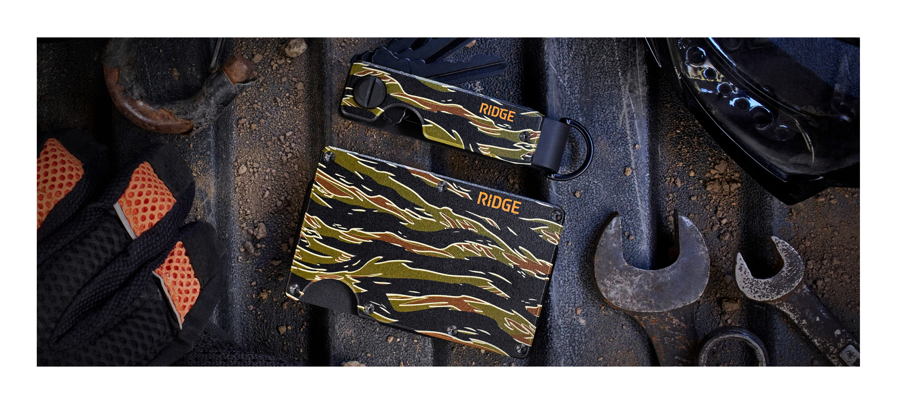 Tools and equipment arranged on a workbench with a camouflage-patterned cloth.