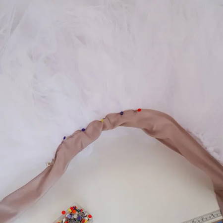 Using long flower pins to attach the waistband to the tutu