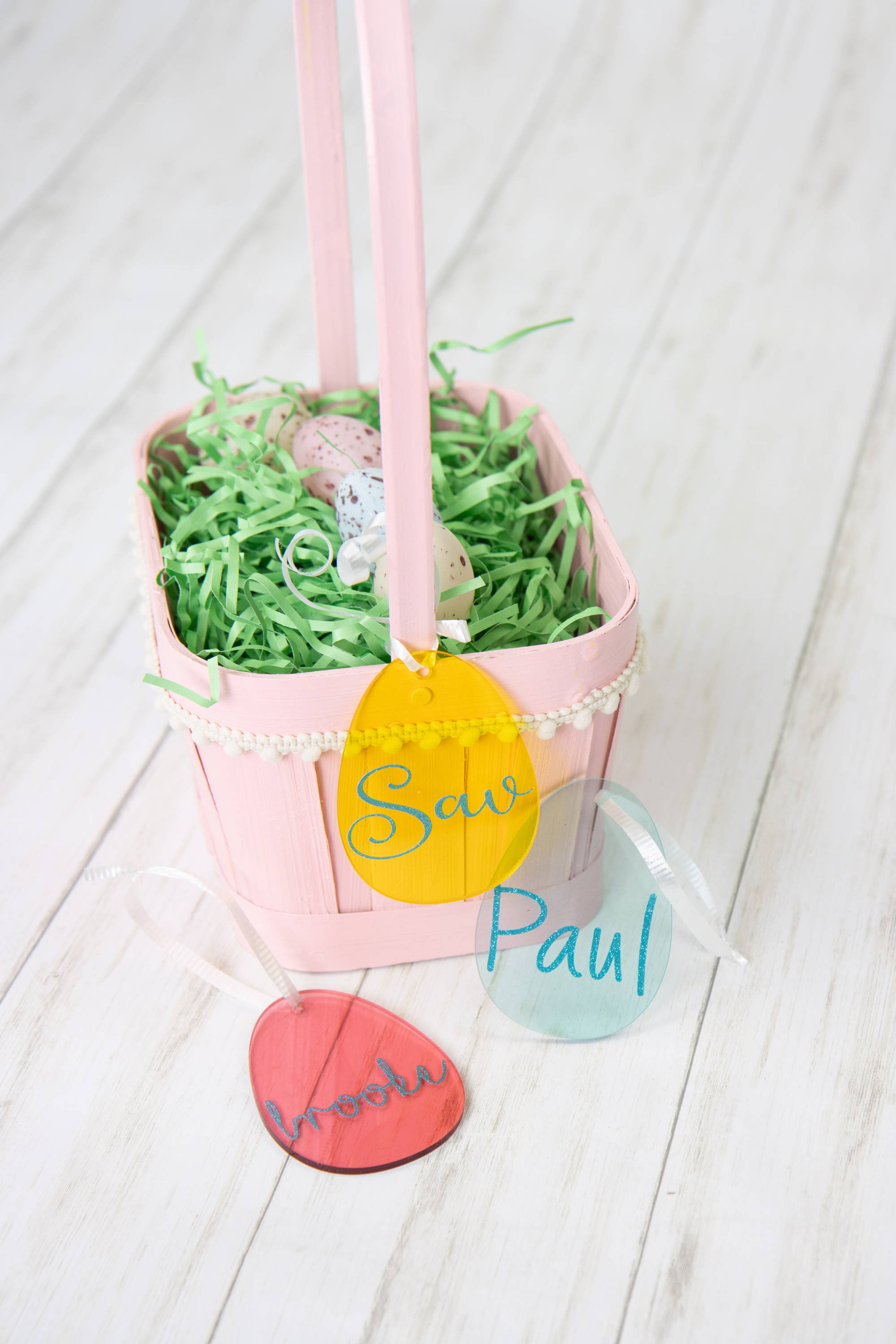 Easter basket with Tags attached. The tags are acrylic Easter eggs that have people's names on them in glitter vinyl 