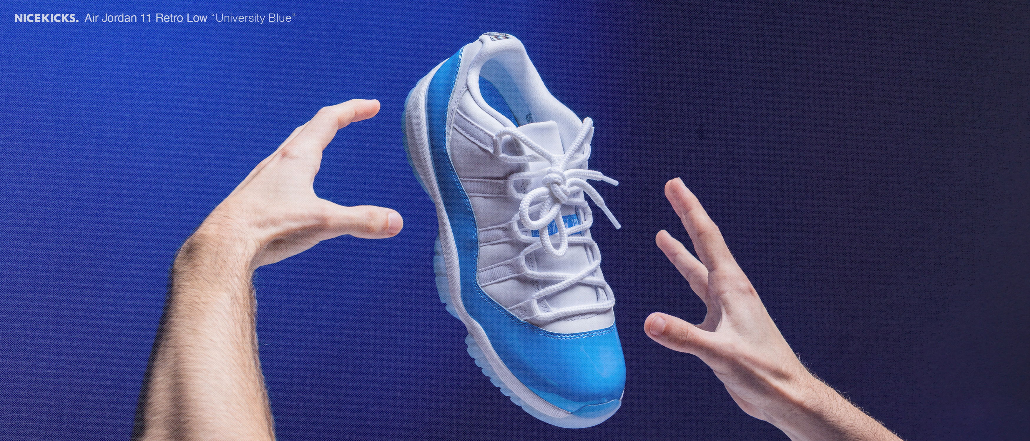 A blue and white sneaker floating between two hands.