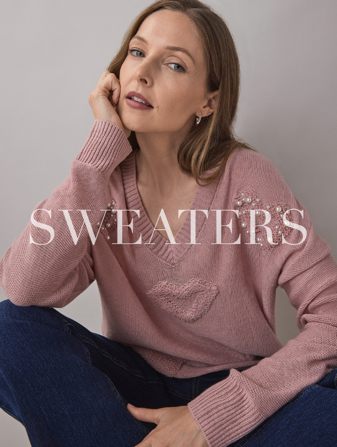 A woman in a pink sweater with text reading 