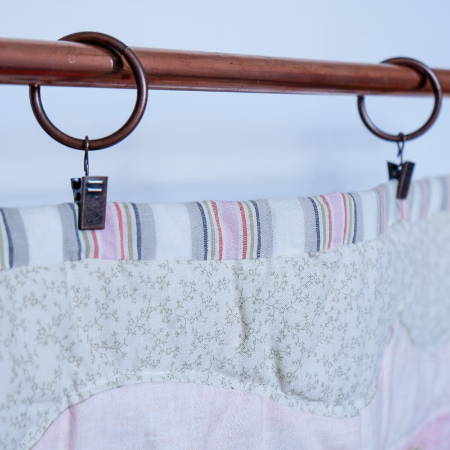 Detail of the quilt hangers used to hang a pastel quilt 