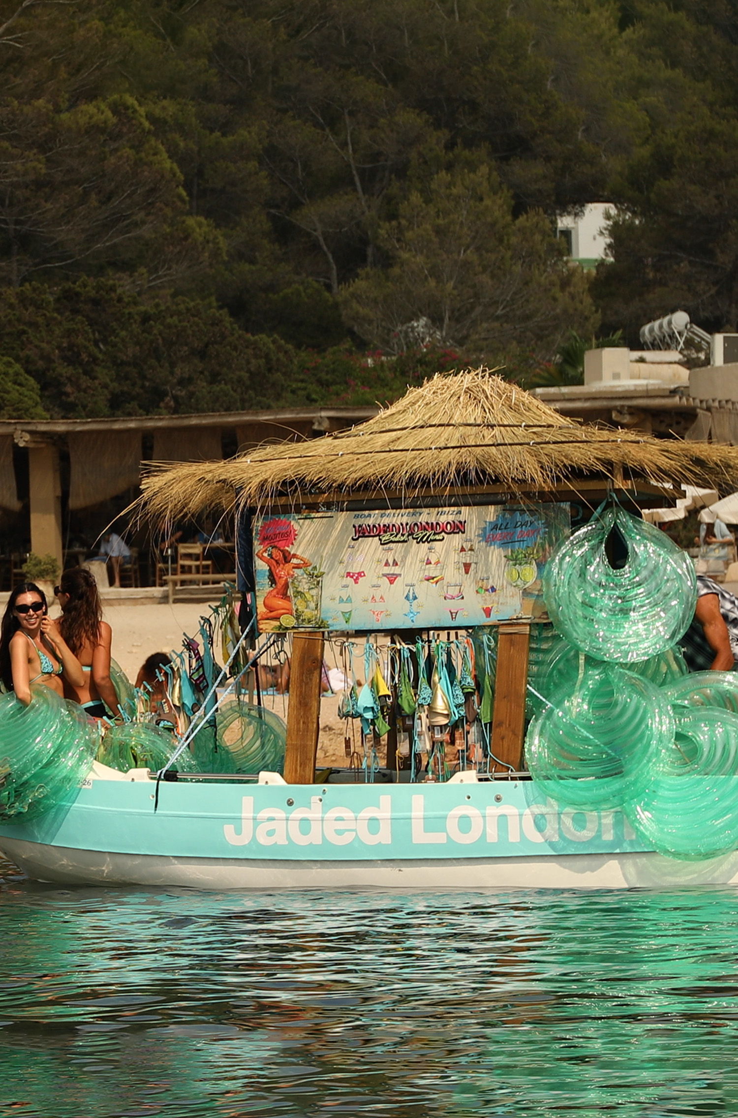 A boat with a thatched roof and people enjoying the water.
