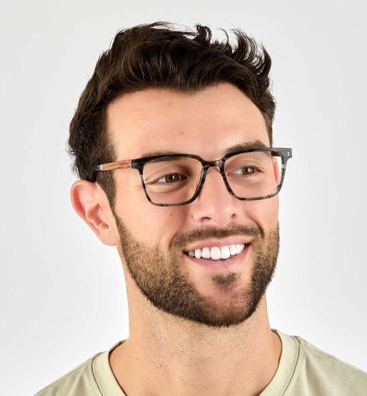 man wearing Trust Grey, Clark Kent style squared eyeglasses, on a white background