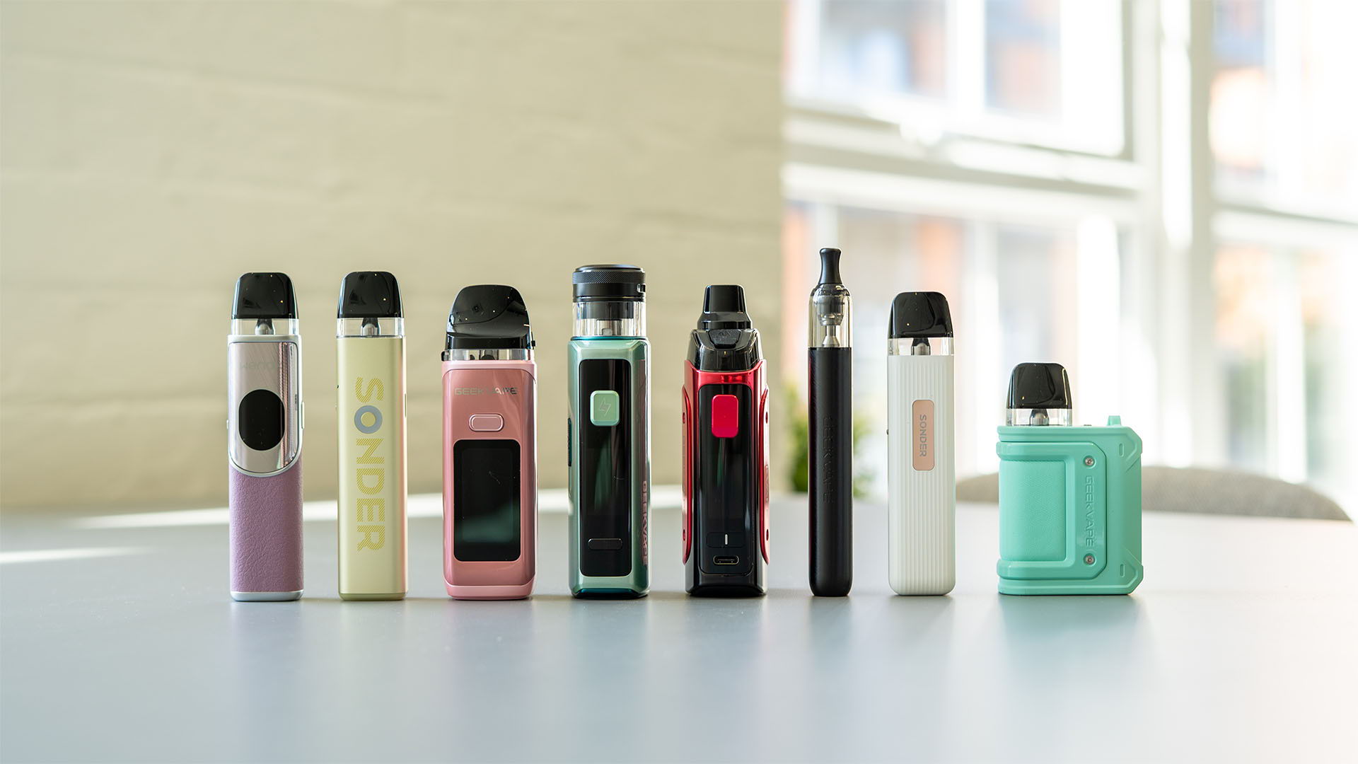 A picture of all of the refillable pod kits Geek Vape sell lined up on table.