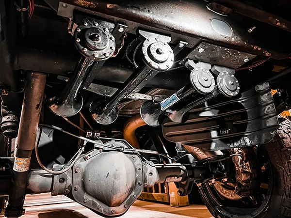Undercarriage view of black Shocker XL train horn bells mounted near the rear axle on Justin's 2017 Chevy 2500HD, install photo 2