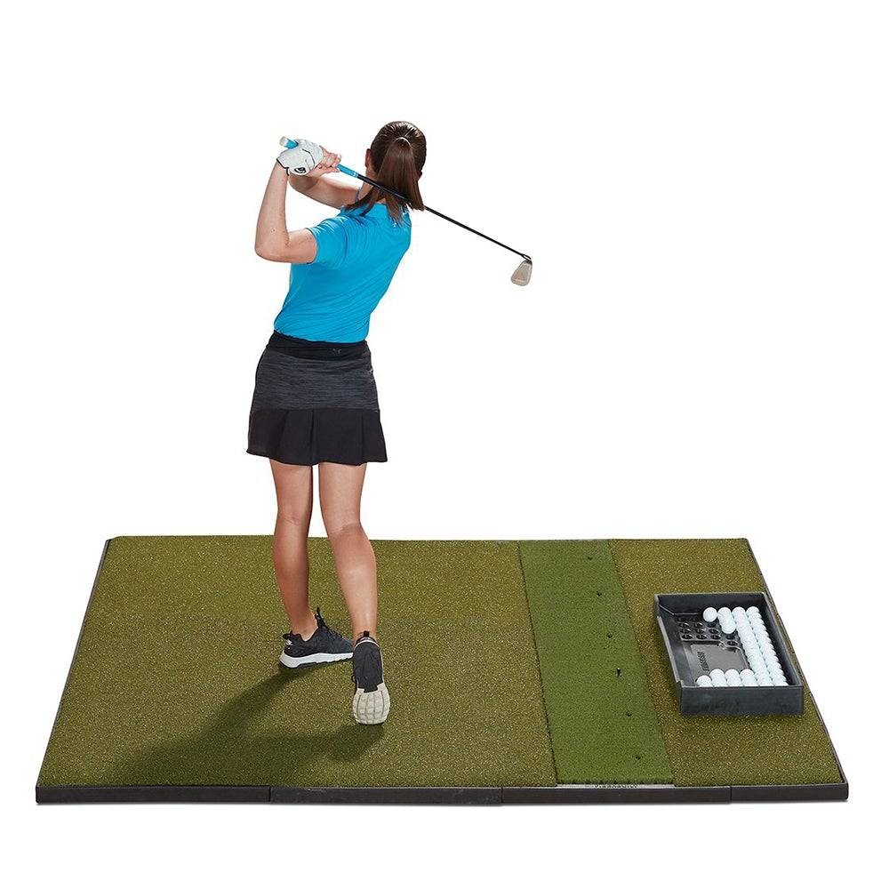 Woman swinging on a Fiberbuilt golf hitting mat