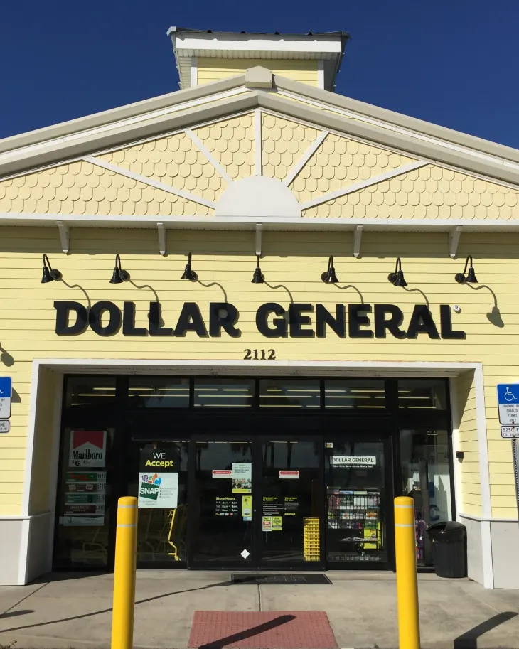 A picture of the Dollar General store with black gooseneck lights that light up the Dollar General signage