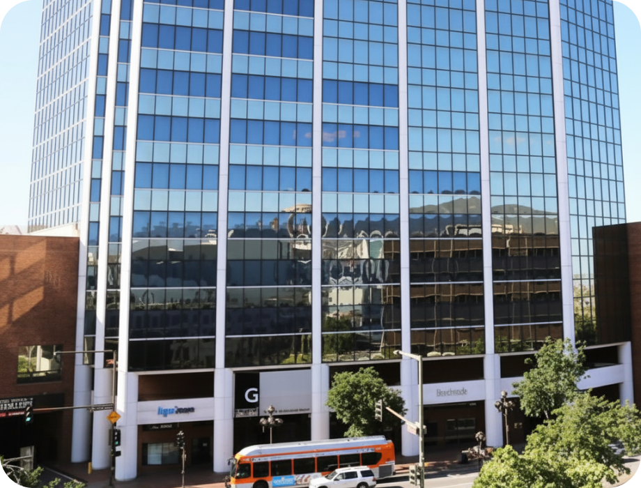 Modern office building with glass facade and nearby bus.