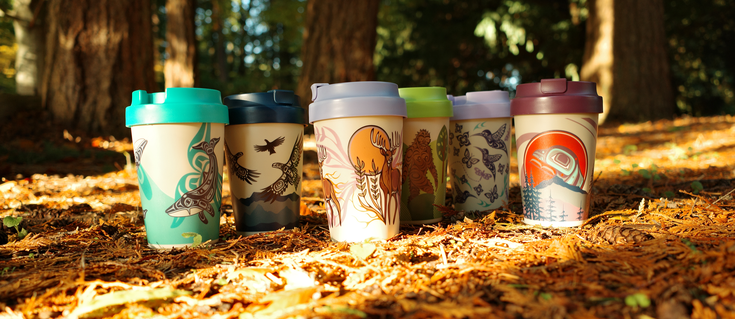 15oz Eco Travel Mugs featuring Indigenous artwork in an autumn forest — Native Northwest