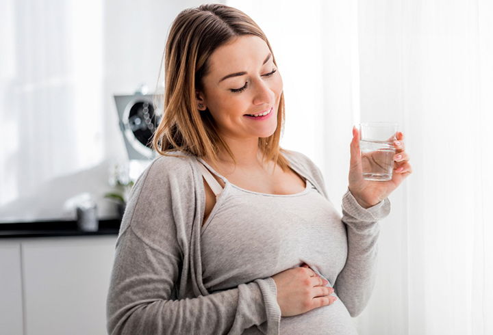Pregnant Woman Drinking Glass of Water - Mobile Image
