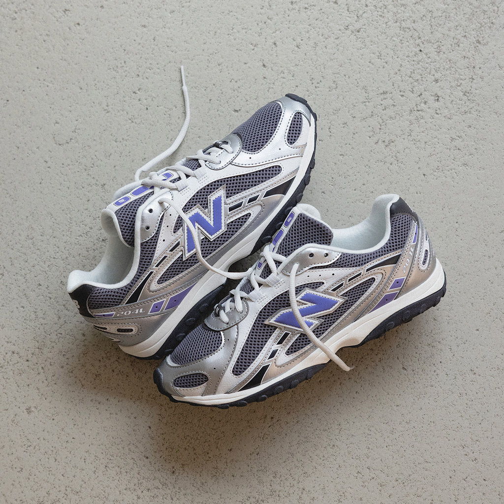A pair of gray and white athletic shoes on a flat surface.