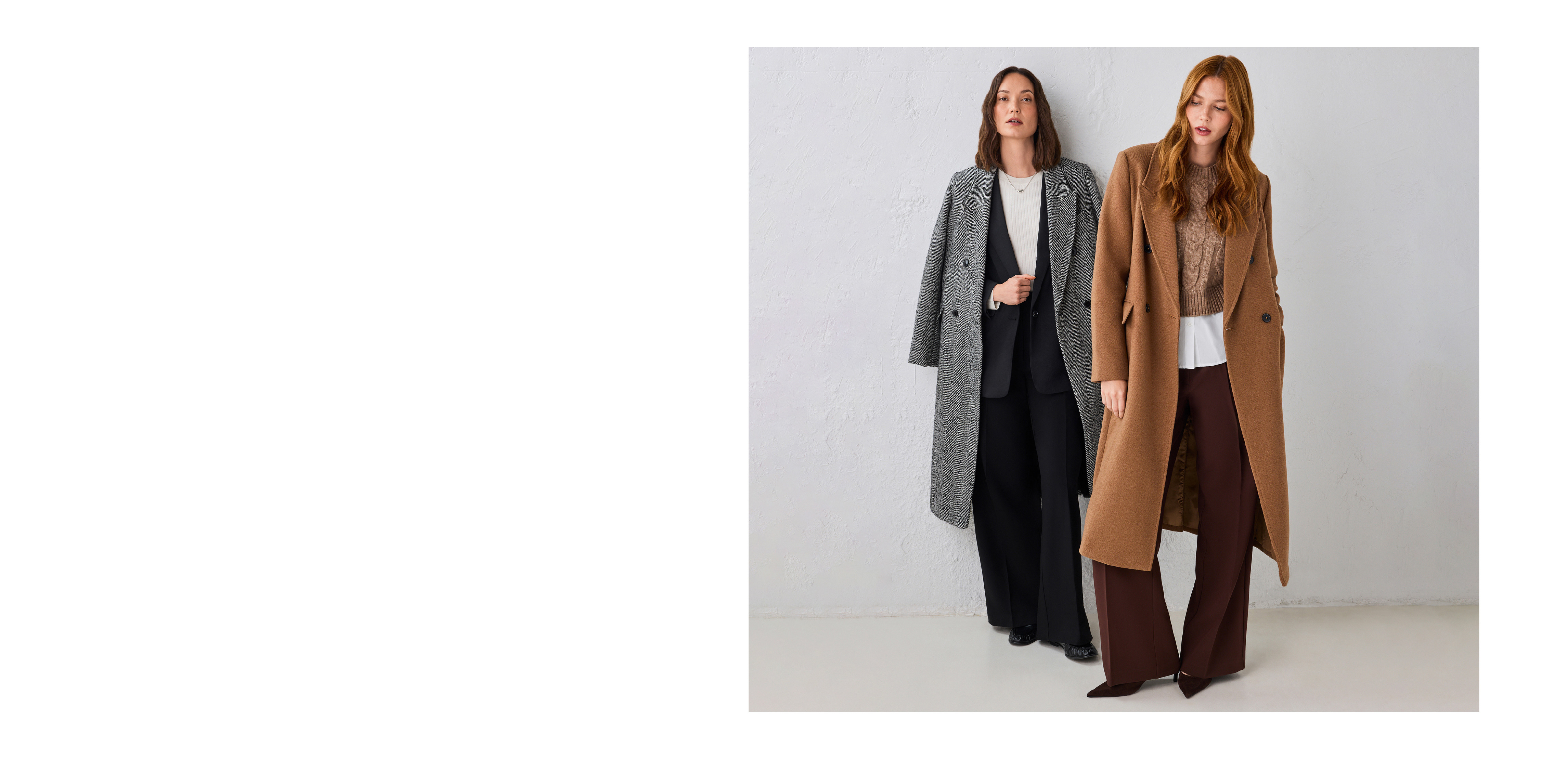 Two women in fashionable coats standing together against a light background.