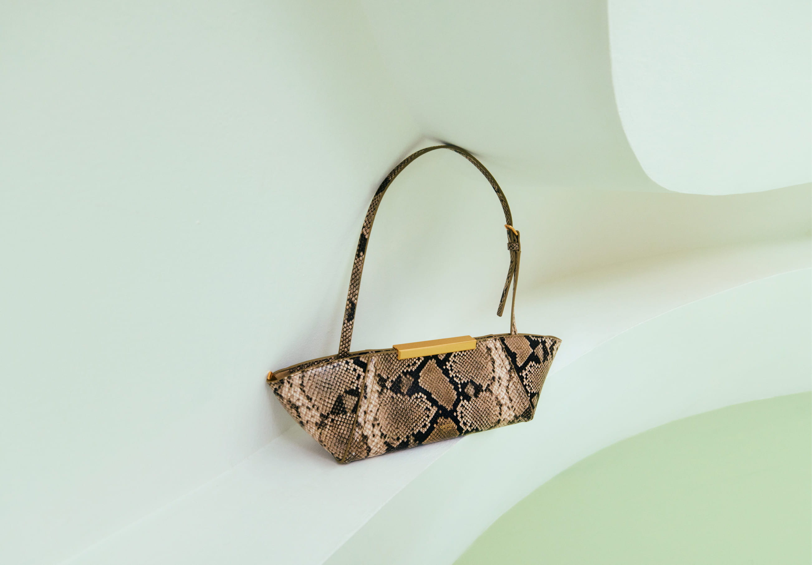 A stylish handbag with a unique brown pattern displayed against a minimalist background.