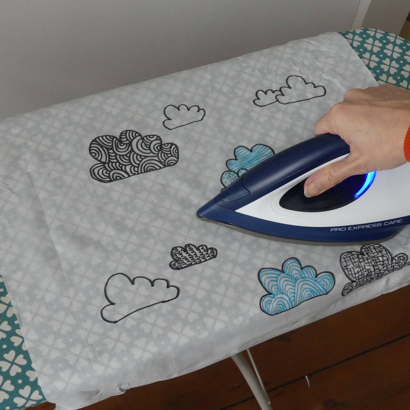 ironing the cloudy fabric design onto white fabric