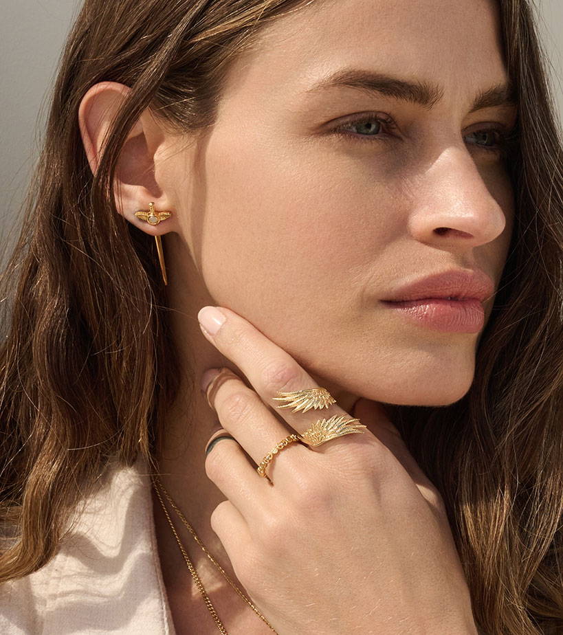 Model wearing Flying Dagger Studs and Wing Wrap Ring in gold vermeil