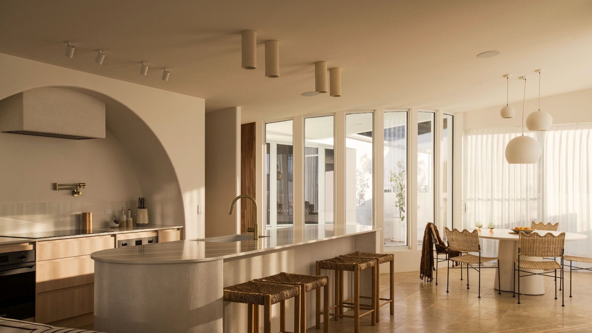 Modern kitchen and dining area with natural light and minimalist design.