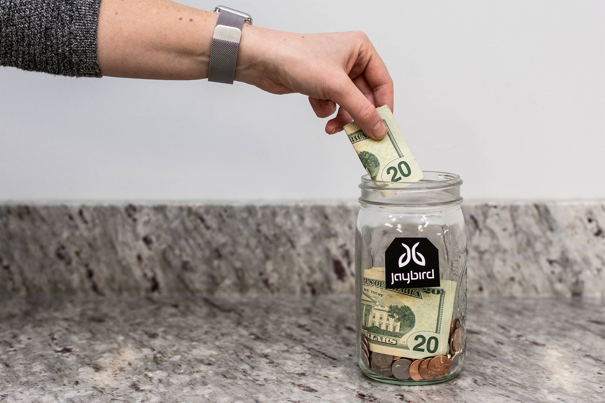 hand putting money in a jar