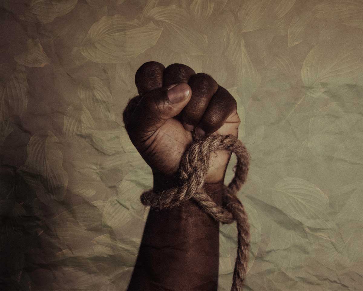 A black fist in the air with a rope around the wrist