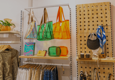 Colorful bags and accessories displayed on shelves in a retail setting.