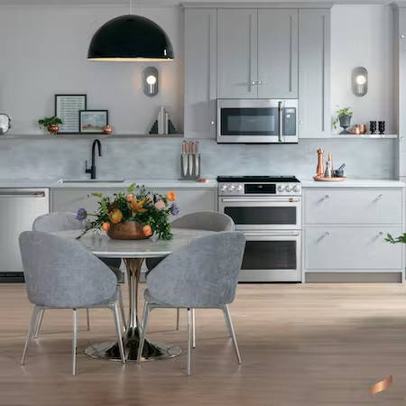 Stainless appliances in contemporary kitchen with light grey cabinets