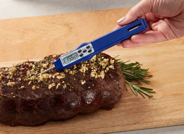 A digital thermometer is going into a piece of meat.