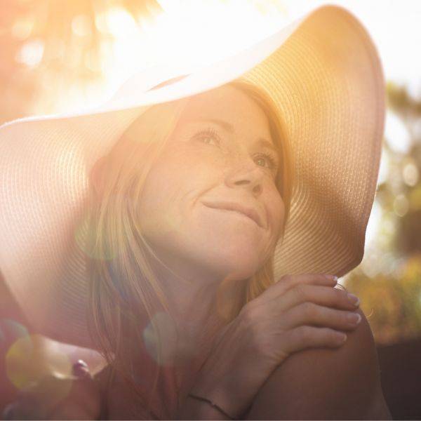 Model wearing sun hat. How to protect skin in summer using ARK Skincare
