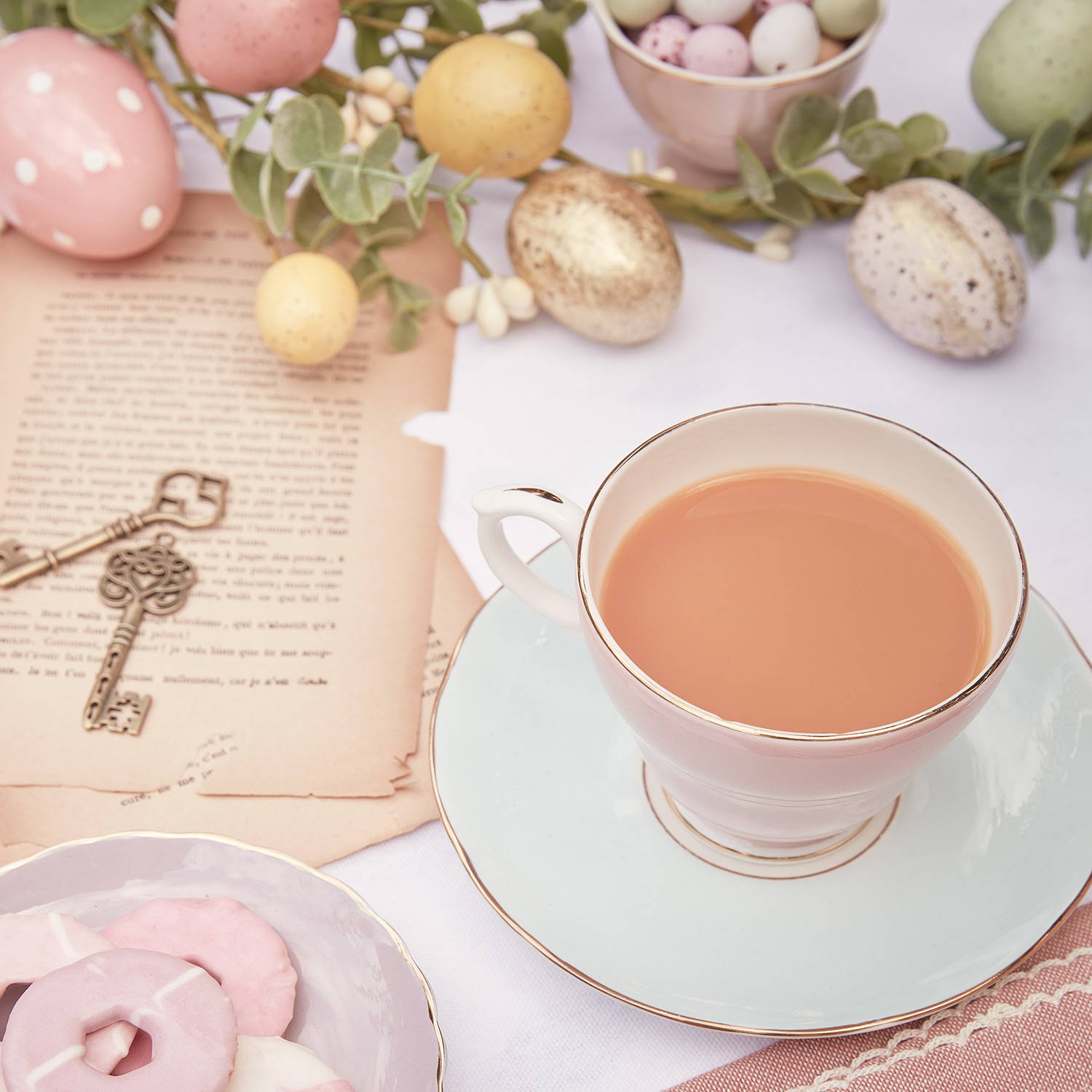 Une table avec une tasse de thé et une guirlande lumineuse en arrière plan. 