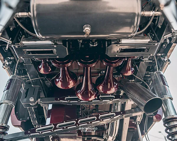 Undercarriage view of burgundy train horns and suspension hardware