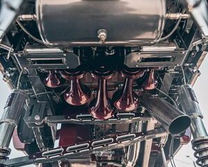 Undercarriage view of burgundy train horns and suspension hardware