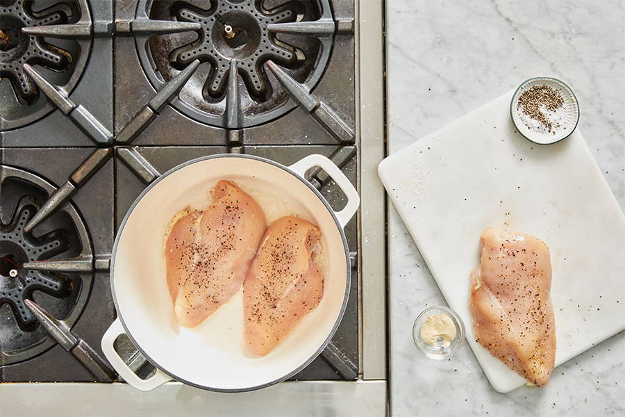 Seasoned Chicken Breasts searing in pan.