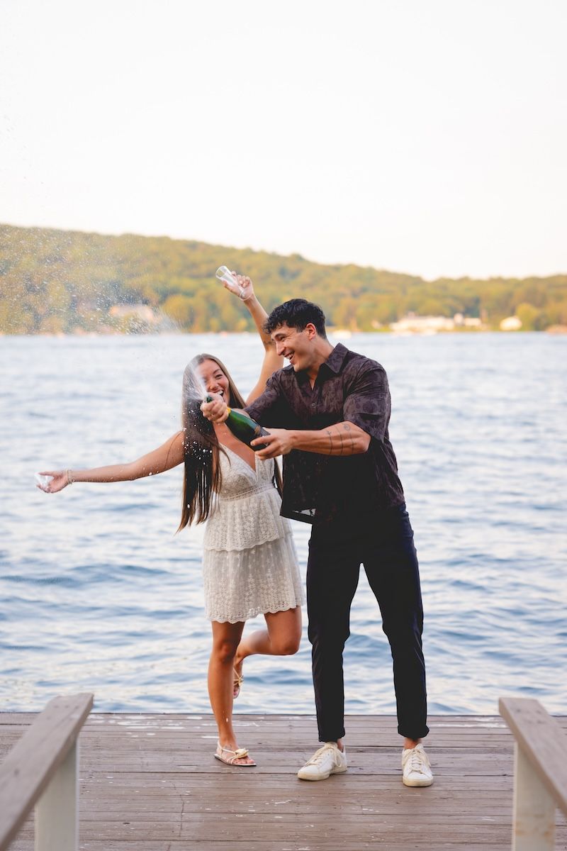 engaged couple opening champagne, candlewood lake, ct