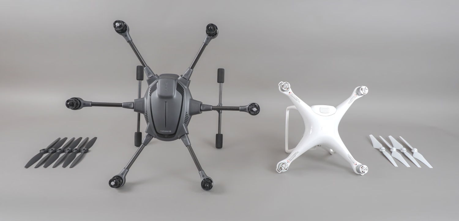 The Typhoon H and Phantom 4 resting on their sides with propellers arranged nearby.