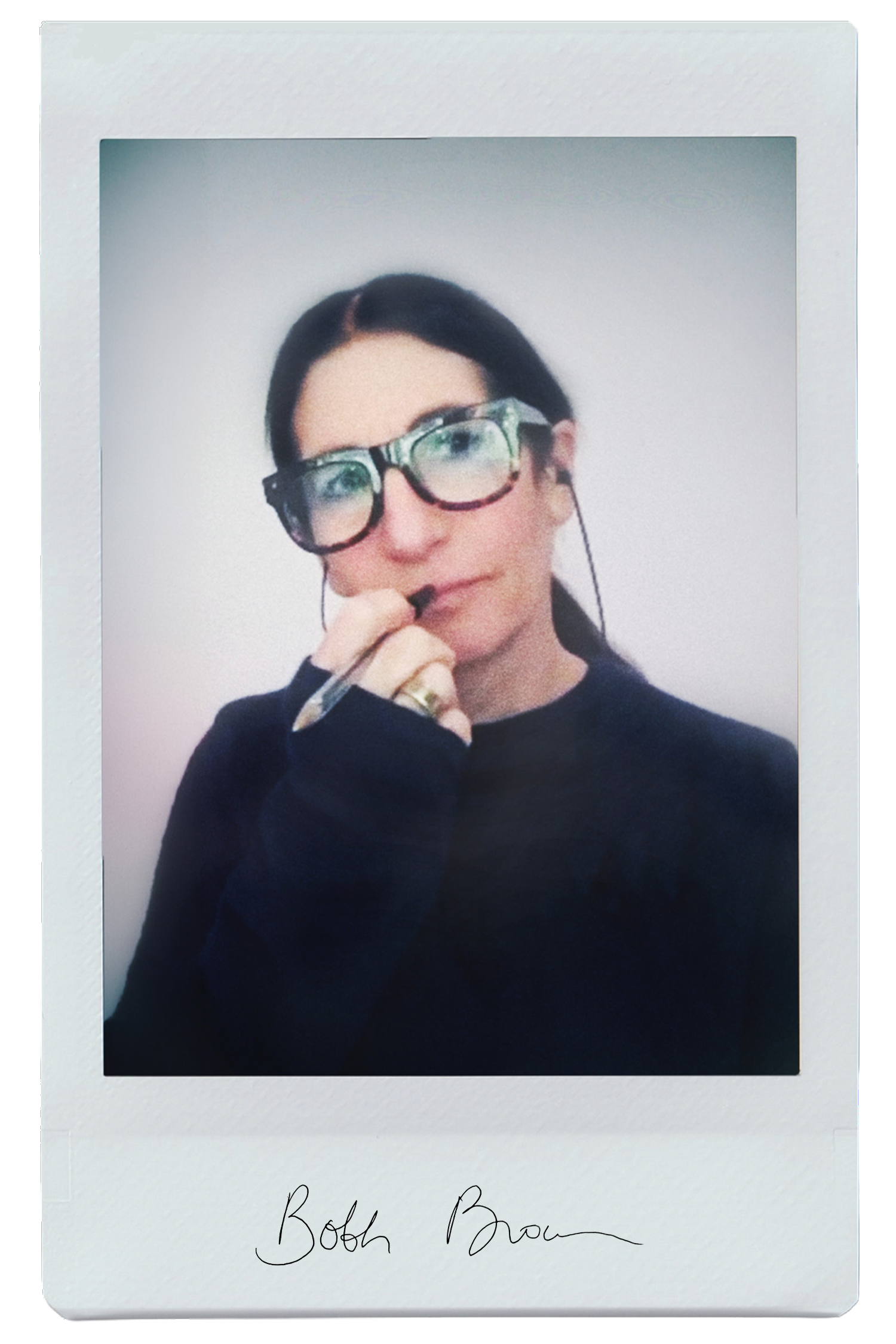 A woman in glasses holding a pen, wearing a dark sweater.