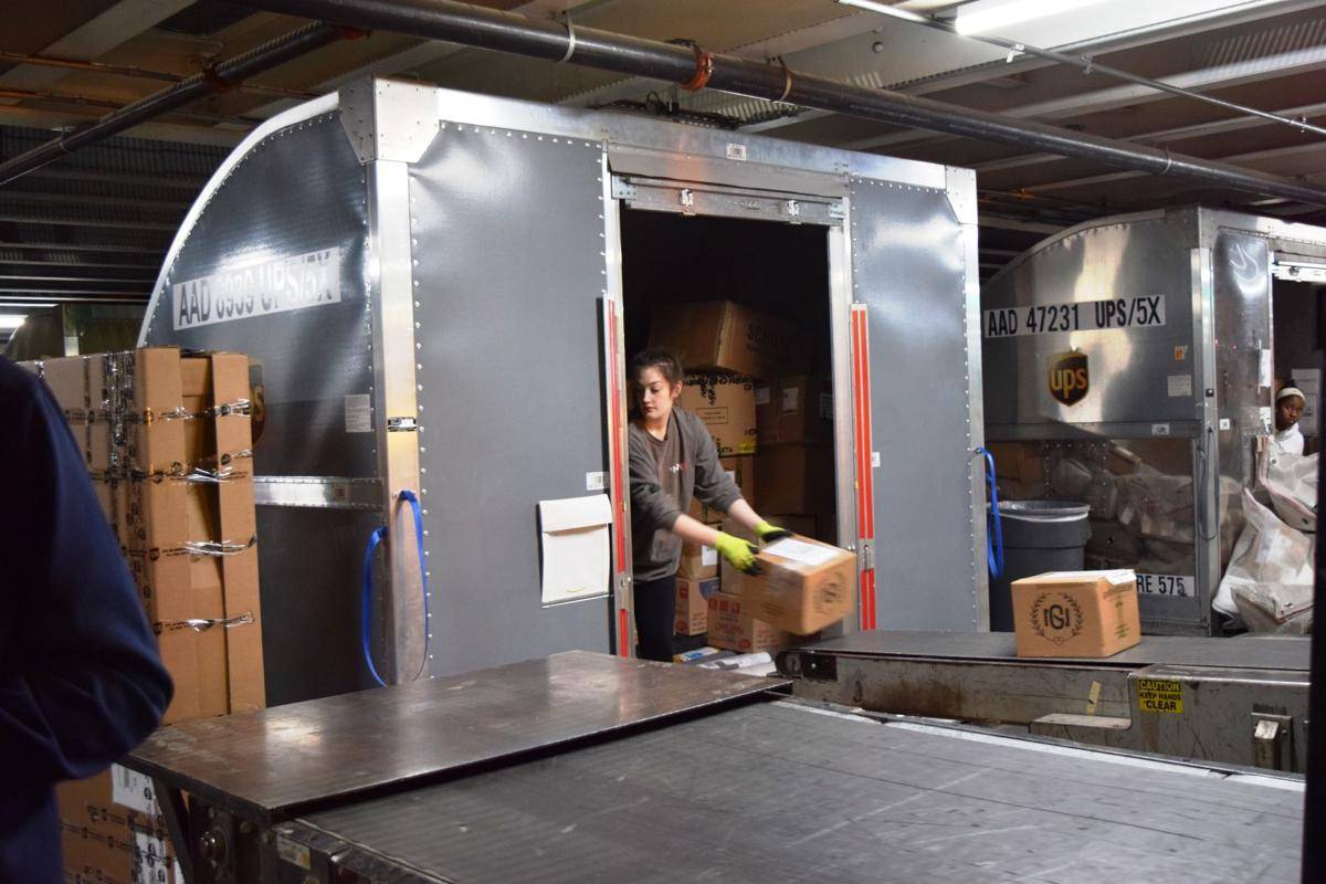 An employee works to sort shipping packages. 