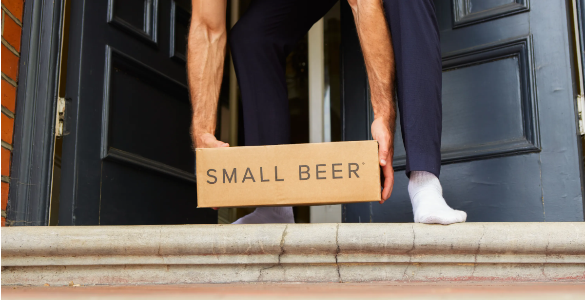 A Small Beer customer collects a delivery box from their front door