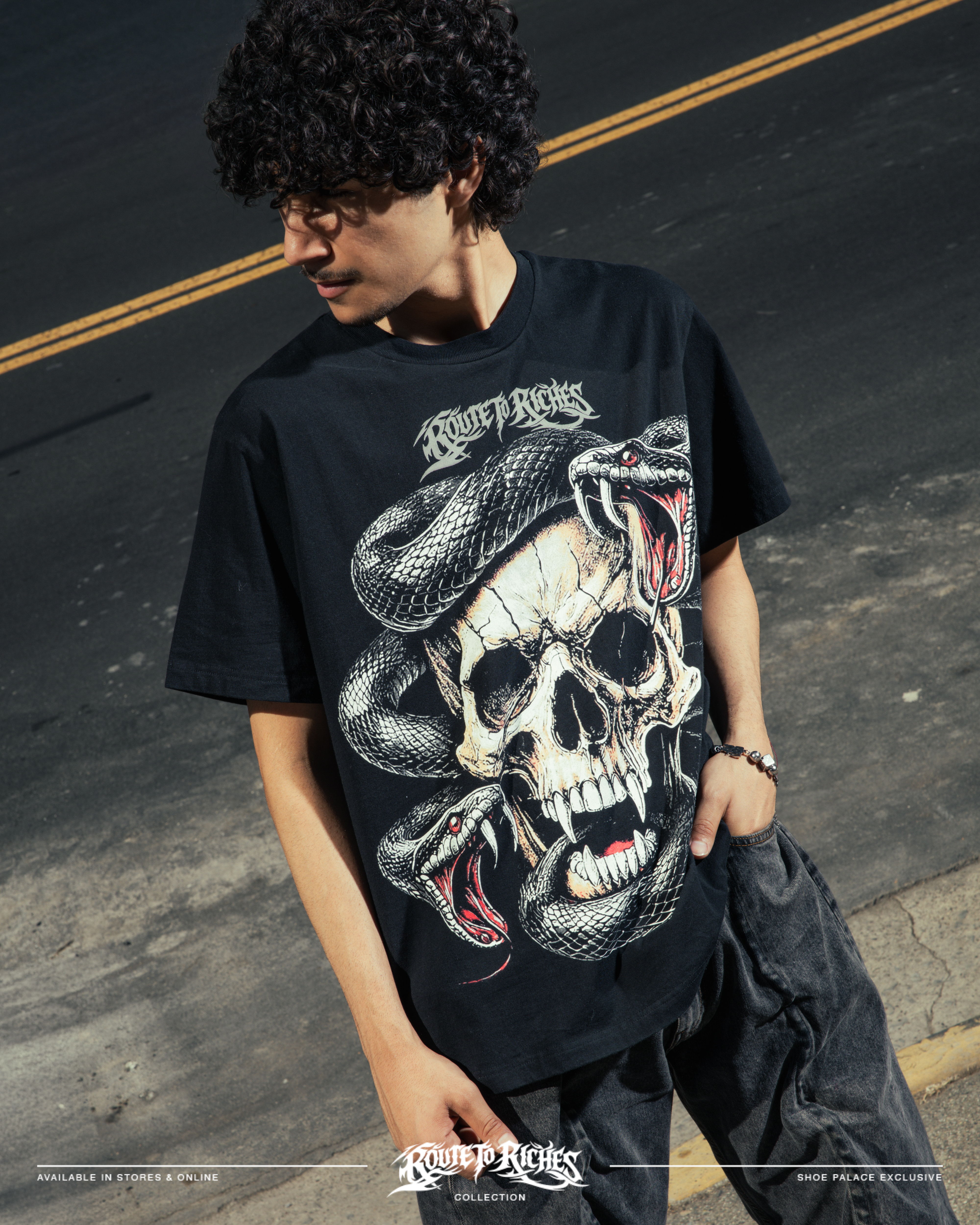 Person wearing a black t-shirt with a skull and snake graphic design.