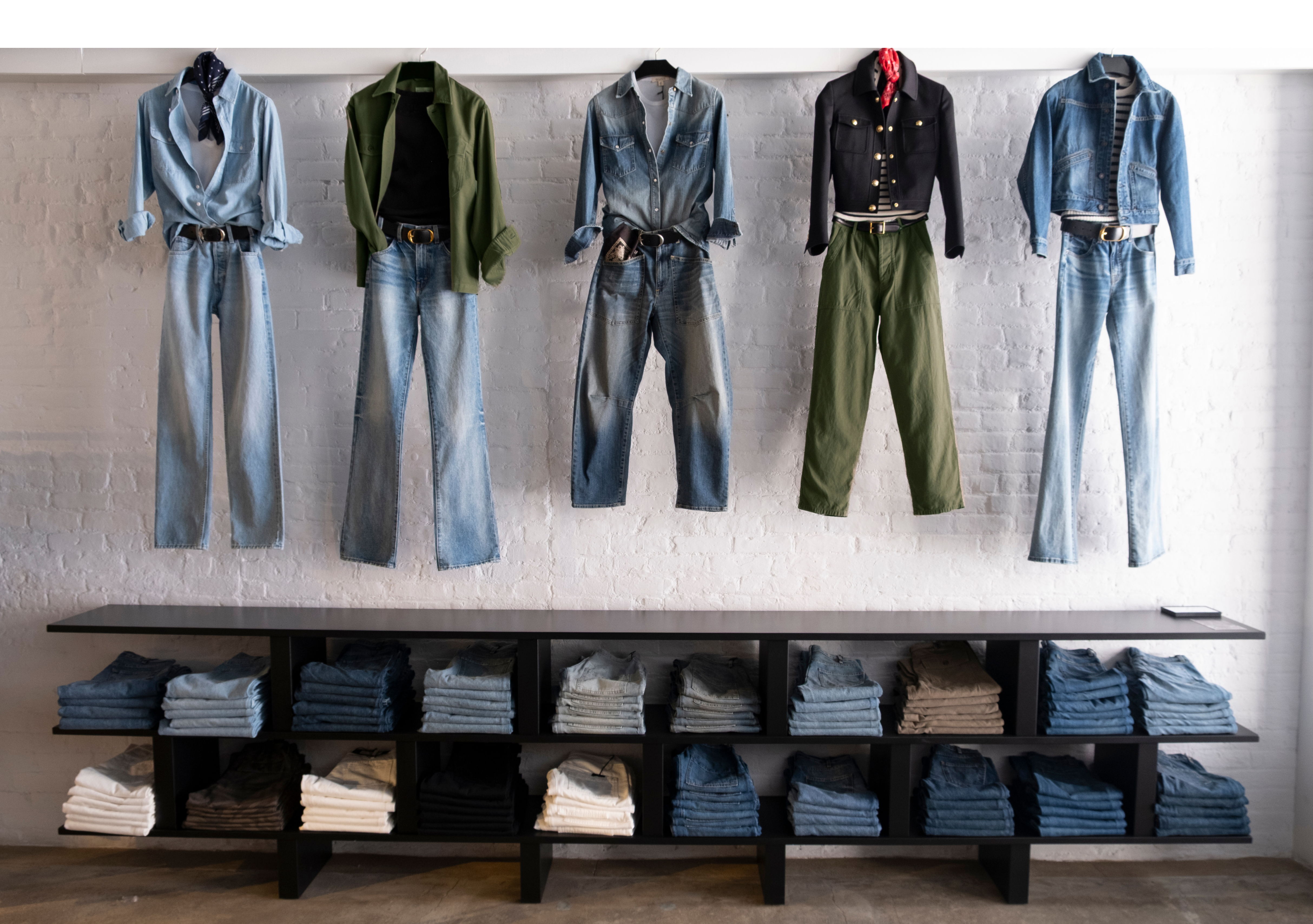Clothes displayed on hangers and shelves in a retail setting.