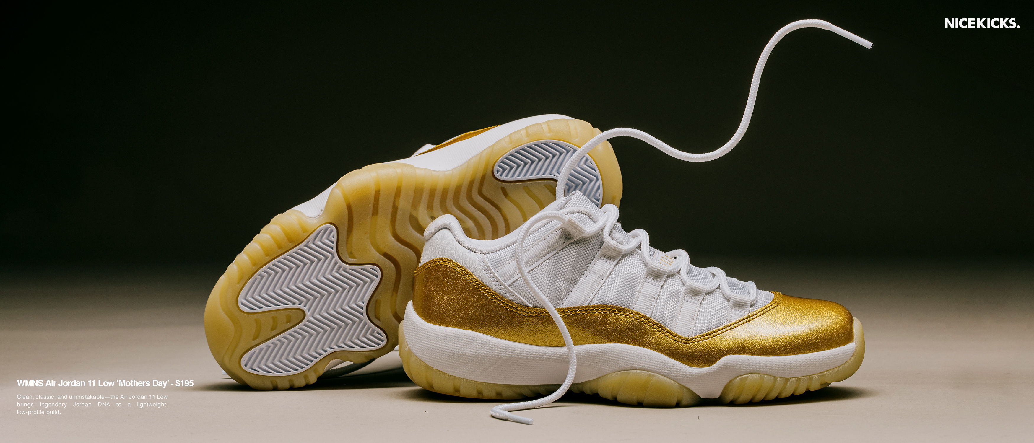 A pair of white and gold athletic shoes on a surface.