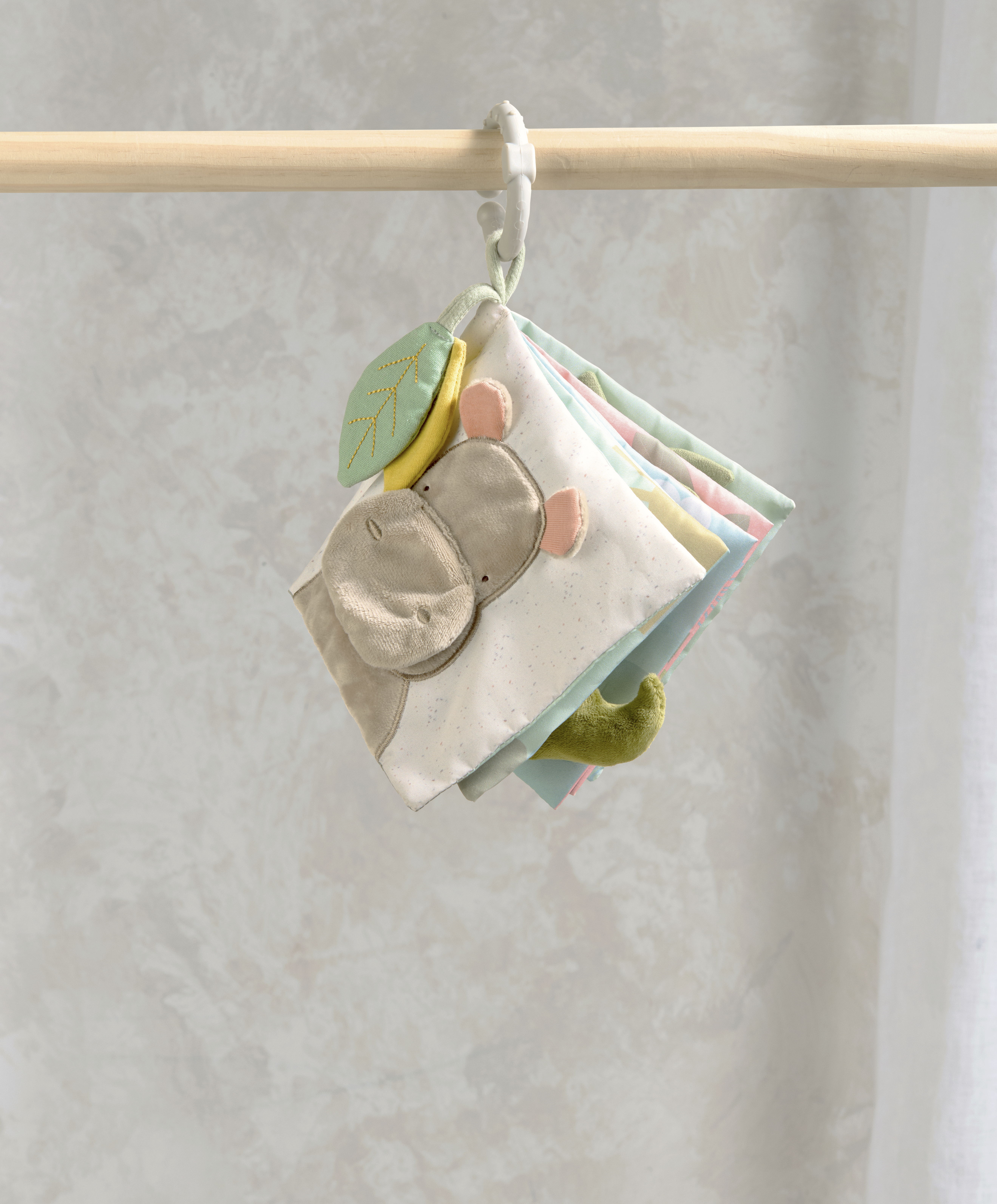 Colorful fabric book hanging on a wooden hanger.