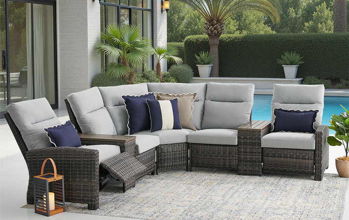 Outdoor sectional sofa with gray cushions and pillows near a pool.