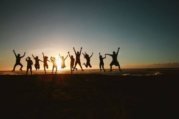 Group Of People Jumping During Sunset