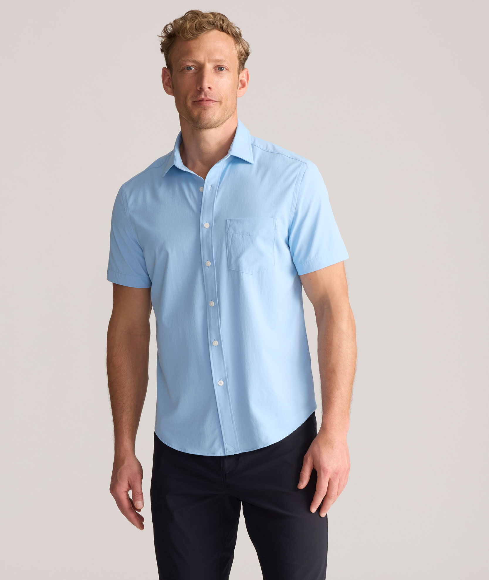 Man wearing a light blue short-sleeve shirt and dark pants.