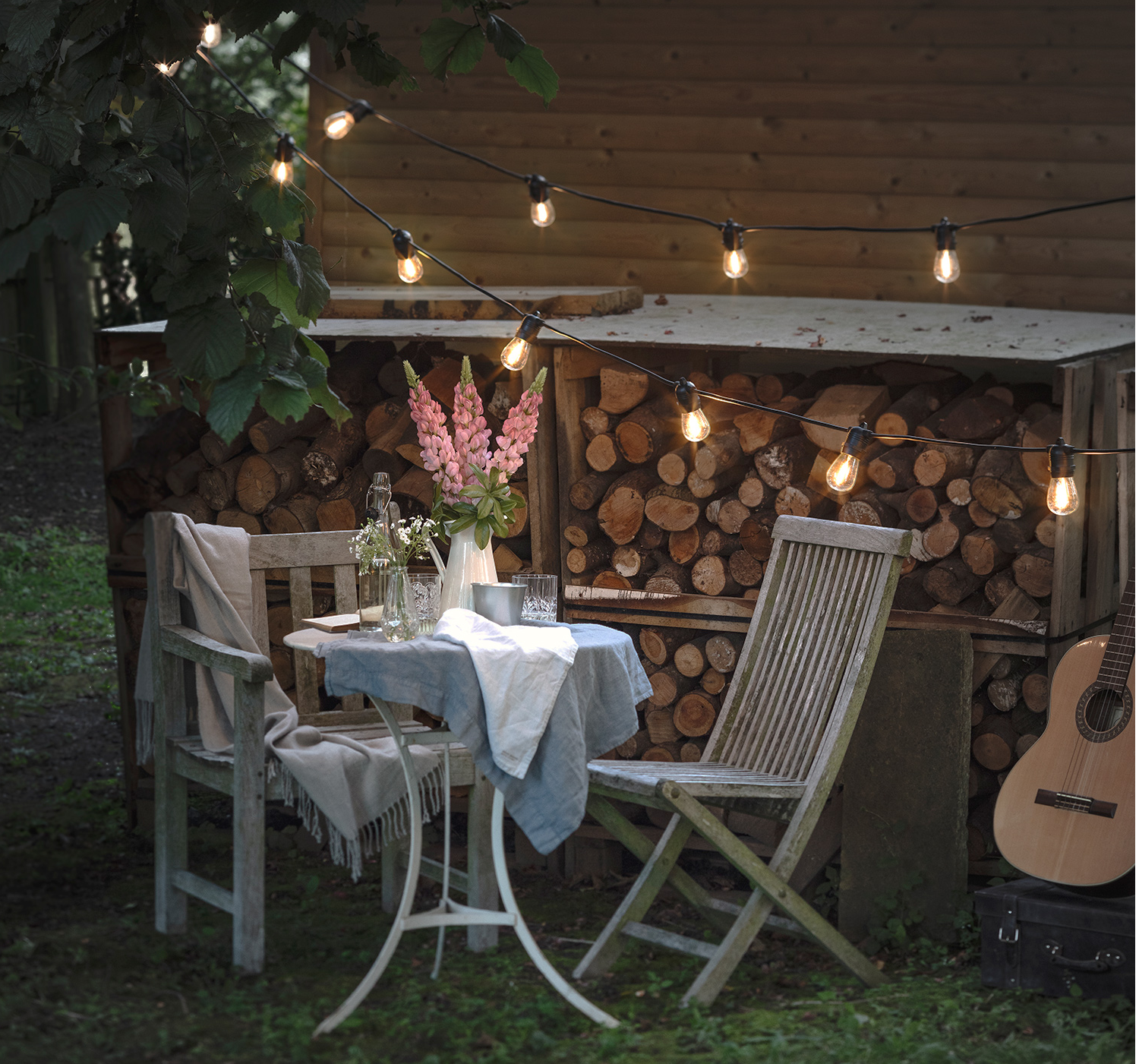 Festoon lights over an outdoor garden setting.