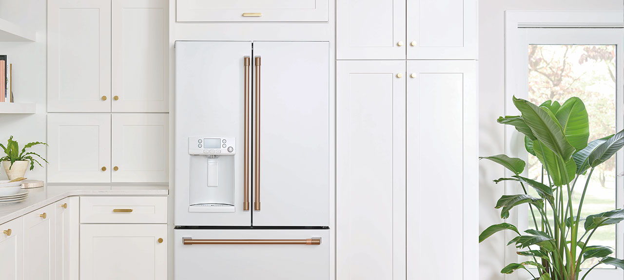 Kitchen with white cabinetry and a matte white refrigerator.