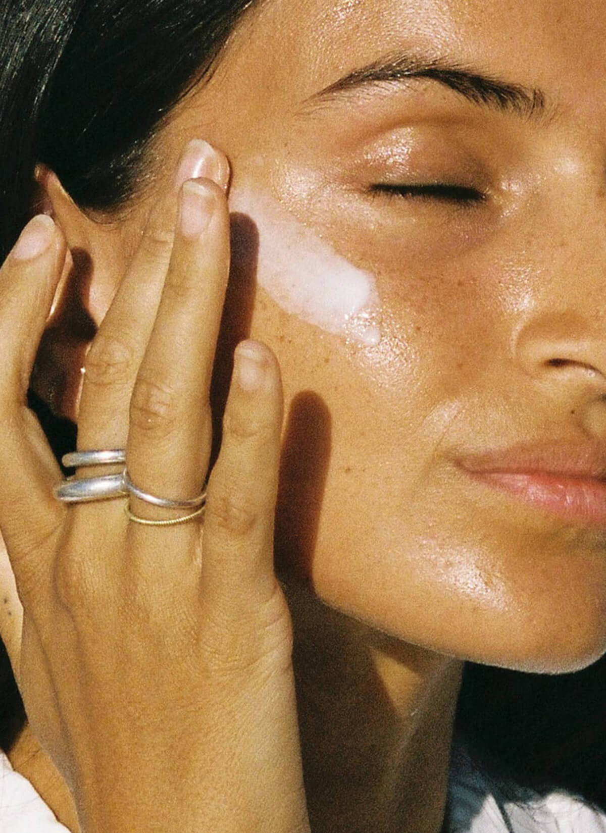 A campaign image of a model applying the Rowse All-Day Serum.